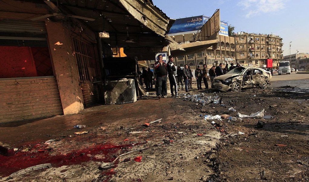 People gather at the site of a car bomb attack in Baghdad, January 15, 2014. Bomb attacks hit the Iraqi capital Baghdad and a village near the northern town of Baquba on Wednesday, killing at least 52 people, police and hospital sources said. REUTERS/Ahme