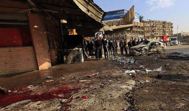 People gather at the site of a car bomb attack in Baghdad, January 15, 2014. Bomb attacks hit the Iraqi capital Baghdad and a village near the northern town of Baquba on Wednesday, killing at least 52 people, police and hospital sources said. REUTERS/Ahme