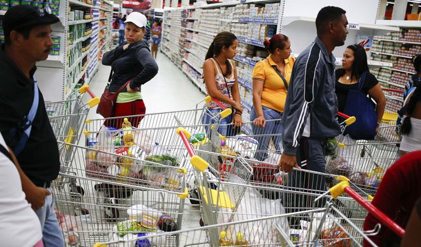 Customers line up to pay for their purchases at a state-run Bicentenario supermarket in Caracas May 2, 2014.  President Nicolas Maduro is introducing a controversial shopping card intended to combat Venezuela's food shortages but decried by critics as a C