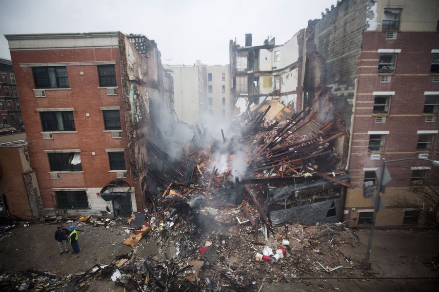 New York City firefighters work at the site of a building explosion and collapse in the Harlem section of New York, March 12, 2014. Two New York City buildings collapsed on Wednesday in an explosion believed to be caused by a gas leak, killing two people,