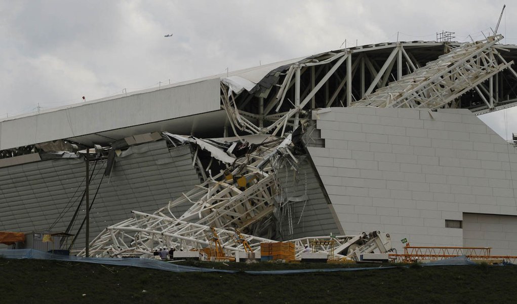 Workers stand near a crane that collapsed on the site of the Arena Sao Paulo stadium, known as "Itaquerao", which will host the opening soccer match of the 2014 World Cup, in Sao Paulo November 27, 2013. A crane collapsed on Wednesday at the construction 