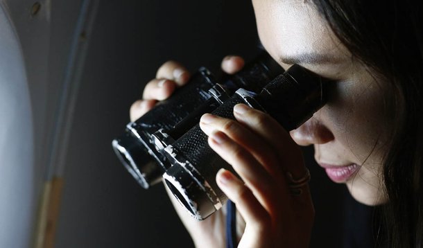 A woman looks for the missing Malaysia Airlines flight MH370, that disappeared from radar screens in the early hours of Saturday, off Con Dao island March 12, 2014. The search for a missing Malaysia Airlines jetliner expanded on Wednesday to cover an area