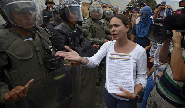 Opposition deputy Maria Corina Machado talks to members of the National Guard during a protest against Venezuelan President Nicolas Maduro, in Caracas on March 16, 2014. Several hundreds of Venezuelans marched Sunday in Caracas against "Cuban interference