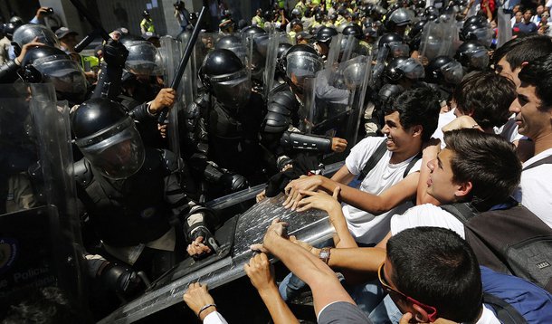 Anti-government medical students scuffle with national policemen during a march demanding medical supplies for hospitals in Caracas March 10, 2014. As violent protests in Venezuela alienate moderates in the opposition and show no signs of toppling Preside