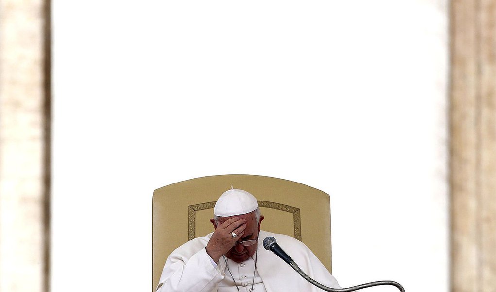 Pope Francis touches his forehead as he leads the general audience in Saint Peter's square at the Vatican April 9, 2014. REUTERS/Alessandro Bianchi   (VATICAN - Tags: RELIGION)