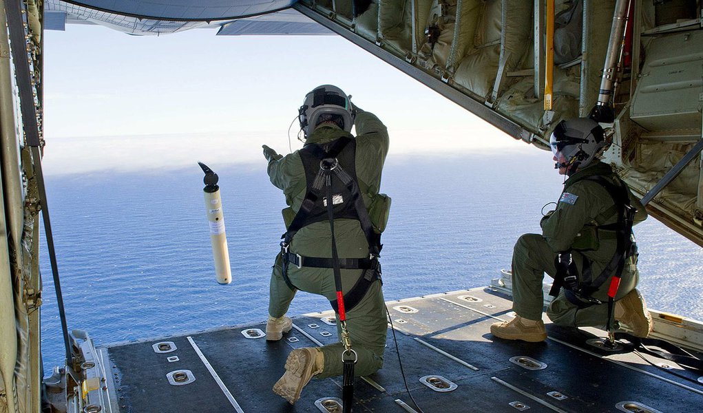 Royal Australian Air Force (RAAF) Loadmasters, Sergeant Adam Roberts (L) and Flight Sergeant John Mancey, launch a 'Self Locating Data Marker Buoy' from a C-130J Hercules aircraft in the southern Indian Ocean during the search for missing Malaysian Airlin