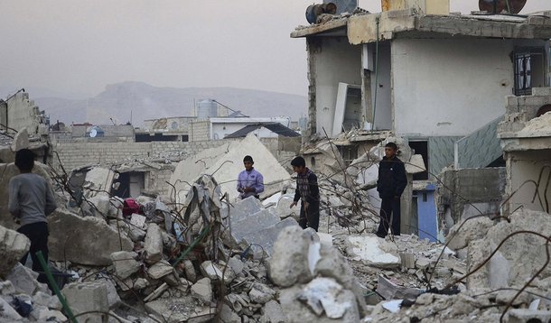 Children walk on rubble of damaged buildings in the Duma neighbourhood of Damascus December 2, 2013. Picture taken December 2, 2013. REUTERS/Yousef Albostany (SYRIA - Tags: POLITICS CIVIL UNREST CONFLICT)