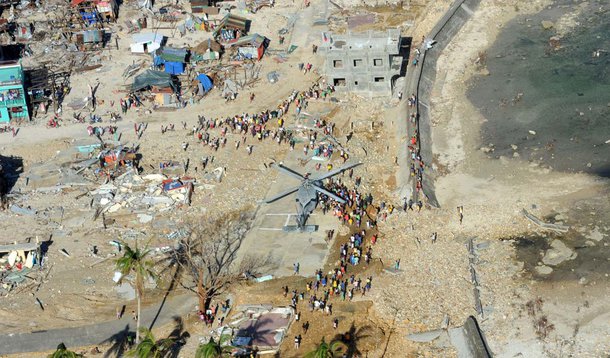 GUIUAN, Eastern Samar Province, Republic of the Philippines (Nov. 17, 2013) Philippine citizens gather around an MH-60S Sea Hawk helicopter from the Golden Falcons of Helicopter Sea Combat Squadron (HSC) 12 as it delivers relief supplies in support of Ope