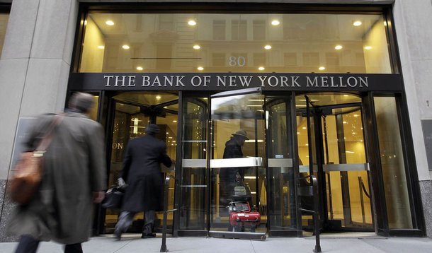FILE - In this April 20, 2009 file photo, people enter the Bank of New York building in New York's Financial District. Bank of New York Mellon Corp. said Wednesday, July 22, 2009, its second-quarter profit fell 43 percent as it repaid a government loan an