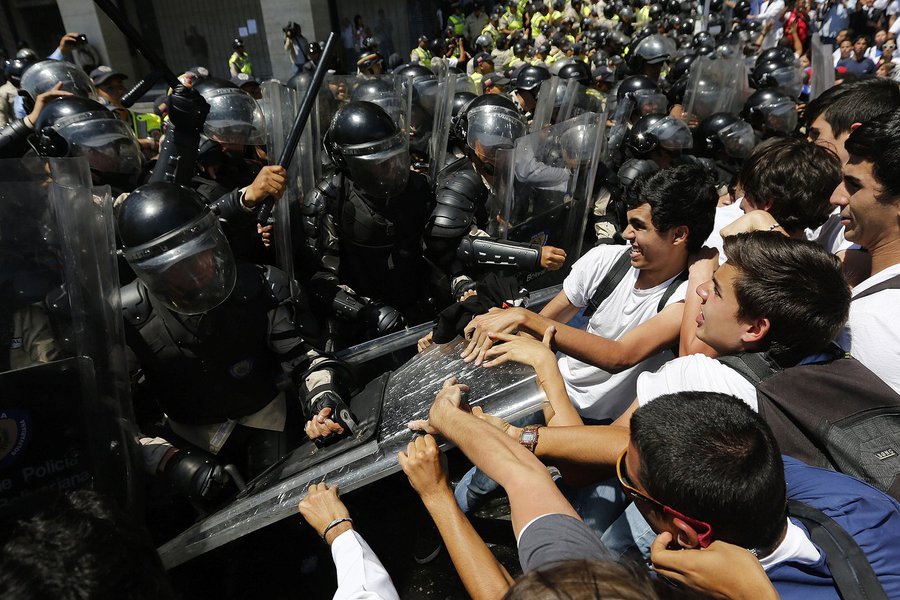 Anti-government medical students scuffle with national policemen during a march demanding medical supplies for hospitals in Caracas March 10, 2014. As violent protests in Venezuela alienate moderates in the opposition and show no signs of toppling Preside
