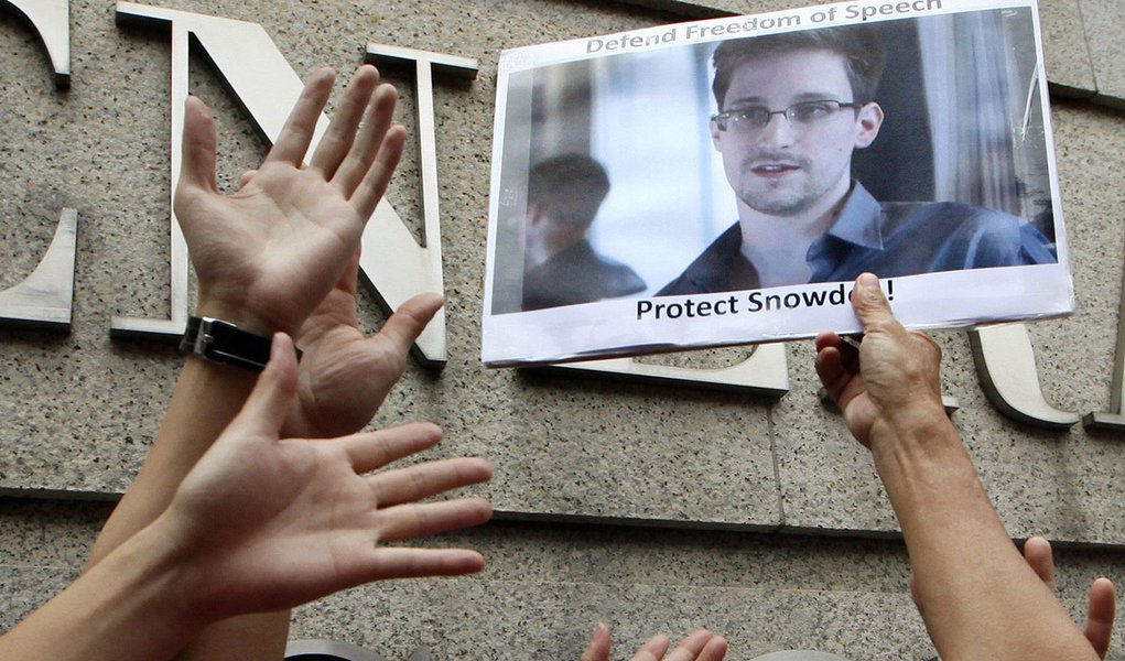 A supporter holds a picture of Edward Snowden, a former CIA employee who leaked top-secret information about U.S. surveillance programs, outside the U.S. Consulate General in Hong Kong Thursday, June 13, 2013. Many citizens of European countries, too, hav