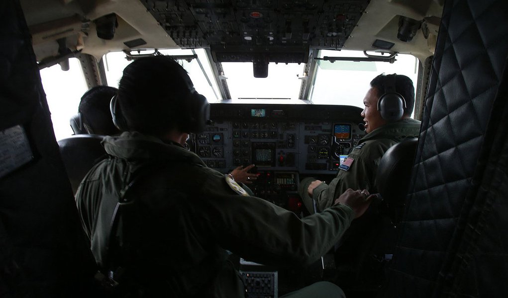 Royal Malaysian Air Force pilots work in the cockpit of a Malaysian Air Force CN235 aircraft during a Search and Rescue (SAR) operation to find the missing Malaysia Airlines flight MH370, in the Straits of Malacca March 13, 2014. REUTERS/Samsul Said (MALA