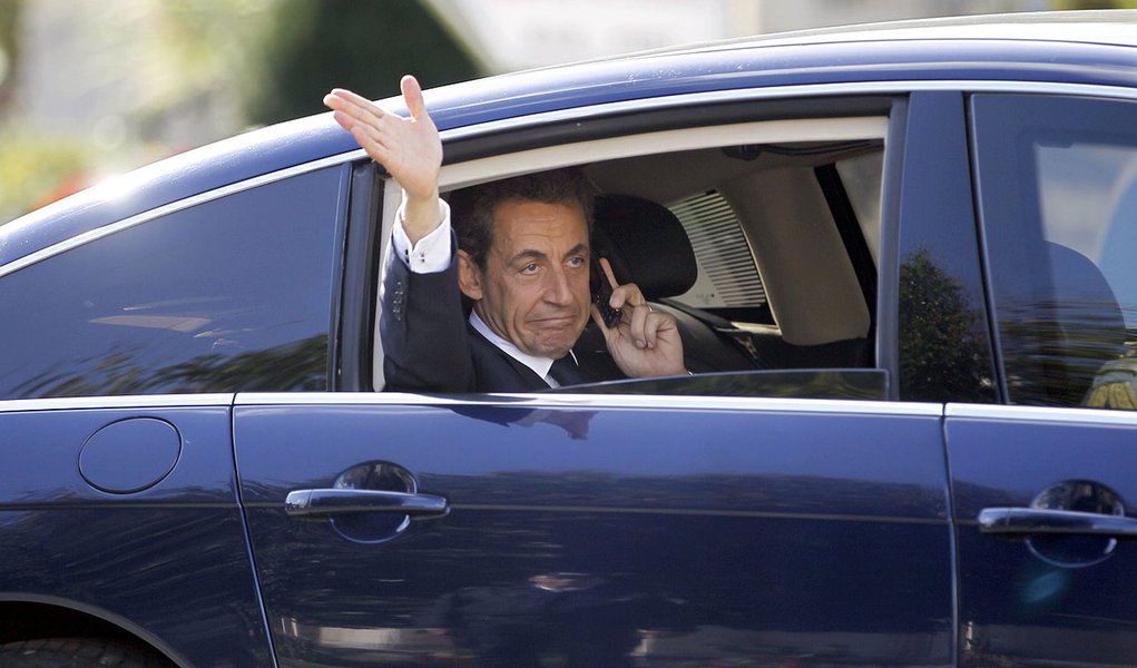 France's President Nicolas Sarkozy waves as he makes a call from his car after a meeting in Change western France October 20, 2011. French President Sarkozy said on Thursday he and first lady Carla Bruni were deeply happy over their baby daughter, the fir