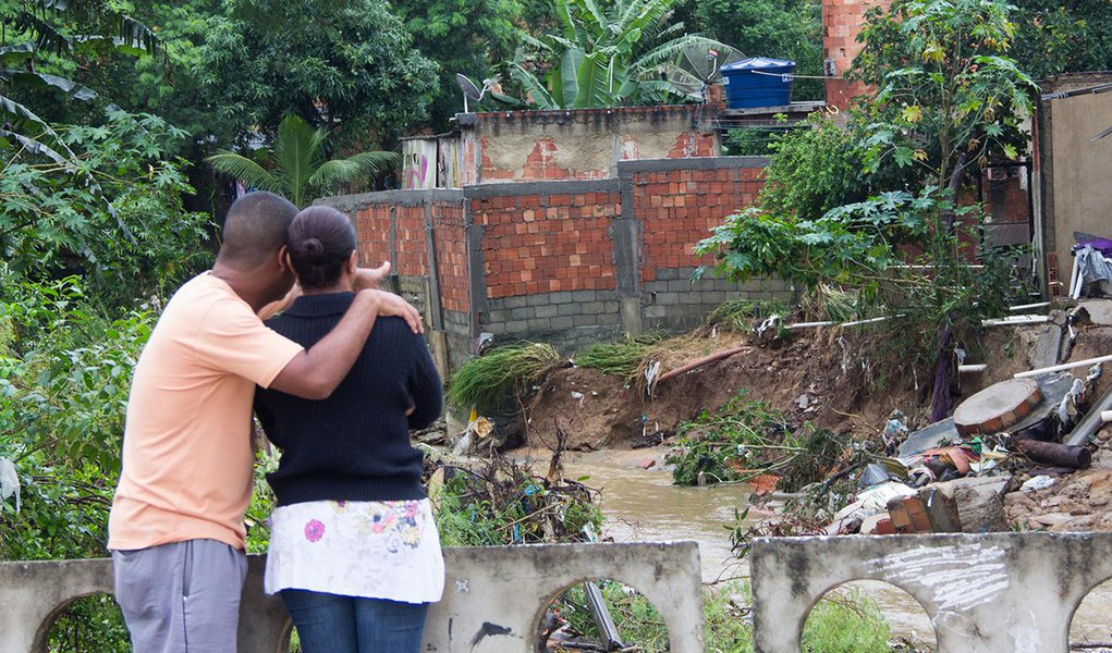 NOVA IGUAÇU,RJ,12.12.2013:CHUVA/RESCALDO/DESALOJADOS - Casal de moradores da Vila Zenith em Austin, Nova Iguaçu (RJ), retorna a residência para verificar os estragos e buscar o que restou, na manhã desta quinta-feira (12). Eles tiveram que abandonar o loc