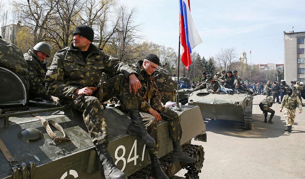 Armed men sit on an armoured personnel carrier with a Russian flag on it in Slaviansk April 16, 2014. Six armoured troop carriers entered the eastern Ukrainian town of Slaviansk on Wednesday carrying the Russian national flag and the banner of pro-Russian