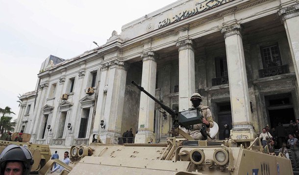 Egyptian soldiers and police officers stand guard with armoured personnel carriers (APC) outside the criminal court in the Mediterranean city of Alexandria, 220 km (137 miles) northwest of Cairo, March 3, 2014. Two Egyptian policemen were sentenced to 10 