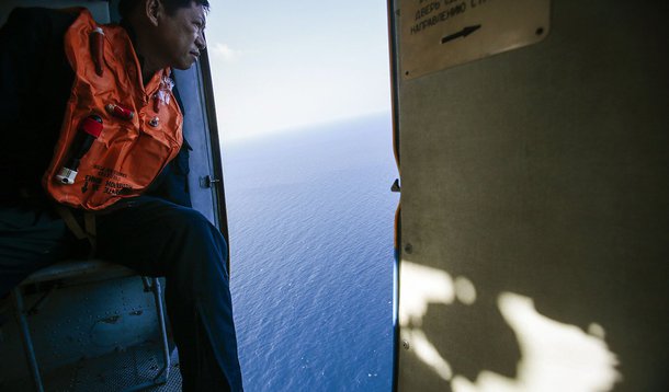 A military personnel looks out of a helicopter during a search and rescue mission off Vietnam's Tho Chu island March 10, 2014. The disappearance of Malaysia Airlines flight MH370, a Boeing 777-200ER jetliner, is an "unprecedented mystery", the country's c