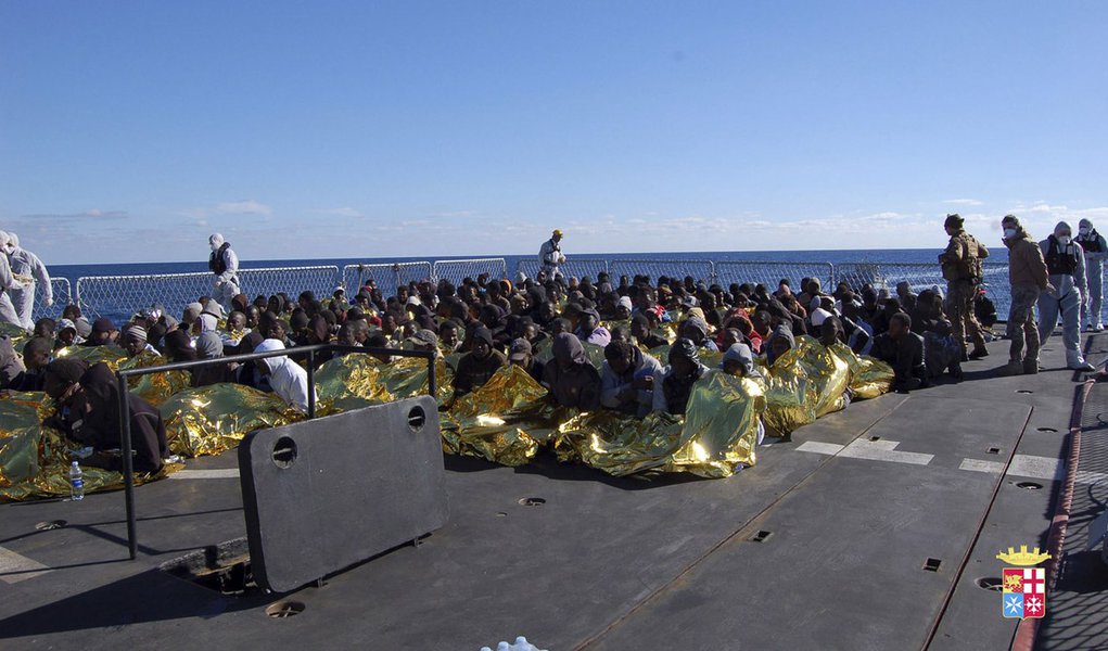 Migrants sit in a Marina Militare vessel during a rescue operation by Italian navy off the coast of the south of the Italian island of Sicily in this January 2, 2014 handout provided by the Italian Marina Militare. The Italian navy has rescued 233 mostly 
