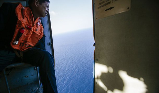 A military personnel looks out of a helicopter during a search and rescue mission off Vietnam's Tho Chu island March 10, 2014. The disappearance of Malaysia Airlines flight MH370, a Boeing 777-200ER jetliner, is an "unprecedented mystery", the country's c