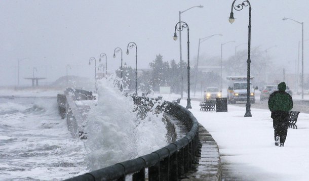 A man jogs past waves crashing against the seawall around high tide during a winter nor'easter snowstorm in Lynn, Massachusetts January 2, 2014.  REUTERS/Brian Snyder  (UNITED STATES - Tags: ENVIRONMENT)