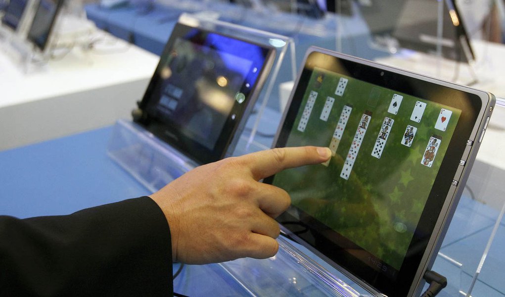 A visitor plays with a tablet PC at the Intel booth during the Computex 2011 computer fair at the TWTC Nangang exhibition hall in Taipei May 31, 2011. Computex, the world's second largest computer show, runs from May 31 to June 4.    REUTERS/Pichi Chuang 