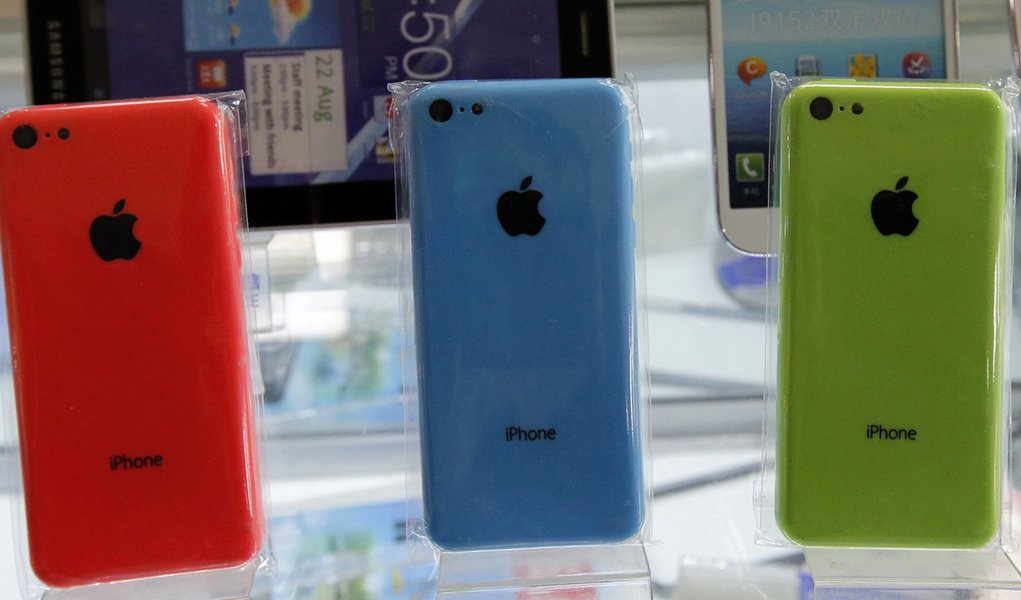 Apple's iPhone 5Cs phones are displayed on racks bearing the logo of China Mobile, at a mobile phone shop in Beijing December 23, 2013.  Apple Inc  said it has signed a long-awaited agreement with China Mobile Ltd to sell iPhones through the world's bigge