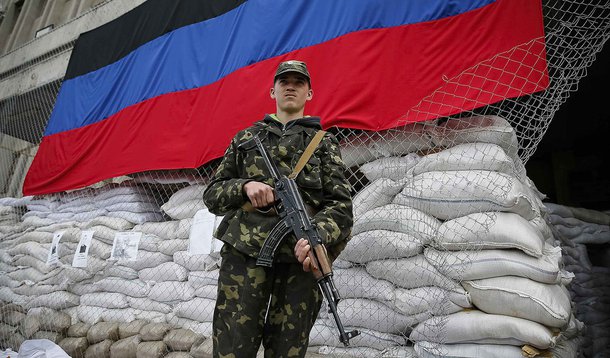 A pro-Russian armed man stands guard near the mayor's office in Slaviansk April 24, 2014. Ukrainian forces clashed with pro-Russian militants as they closed in on the separatist-held city of Slaviansk on Thursday, seizing rebel checkpoints and setting up 