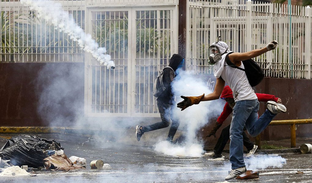 An anti-government protester attempts to catch a gas canister thrown by police during a protest against President Nicolas Maduro's government in Caracas May 8, 2014. Venezuelan security forces on Thursday rounded up hundreds of youth activists and dismant