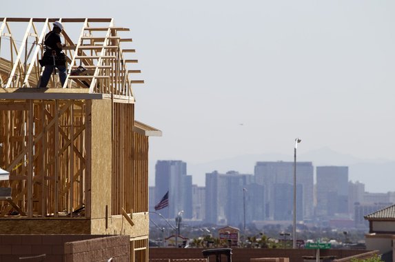 A carpenter works on a new home at a residential construction site in the west side of the Las Vegas Valley in Las Vegas, Nevada April 5, 2013.  Las Vegas Strip casinos are shown in the background. The buying of foreclosed homes and other distressed homes