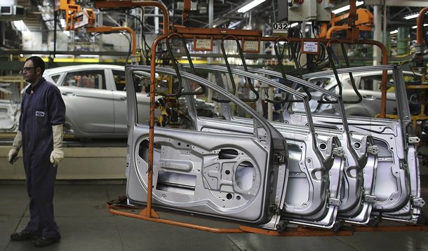 A Brazilian worker stands next to doors of a Ford car on a assembly line at Sao Bernardo do Campo Ford plant, near Sao Paulo August 13, 2013. The pace of vehicle production in Brazil slipped in July to the lowest daily rate in five months as factories, fa