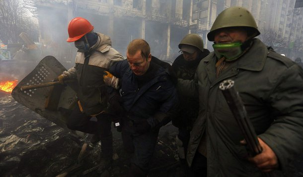 Anti-government protesters detain a policeman (2nd L) during clashes in the Independence Square in Kiev February 20, 2014. Ukrainian anti-government protesters are holding 67 policemen hostage in the capital, the country's interior ministry said on Thursd