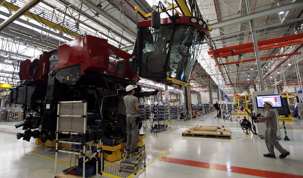 Employees work at a harvest machine assembly line at the Case Agricultural Machinery Plant in Sorocaba, 100 km (62 miles) west of Sao Paulo, September 18, 2013. For the first time in history, Brazil is expected to export more soybeans than it crushes dome