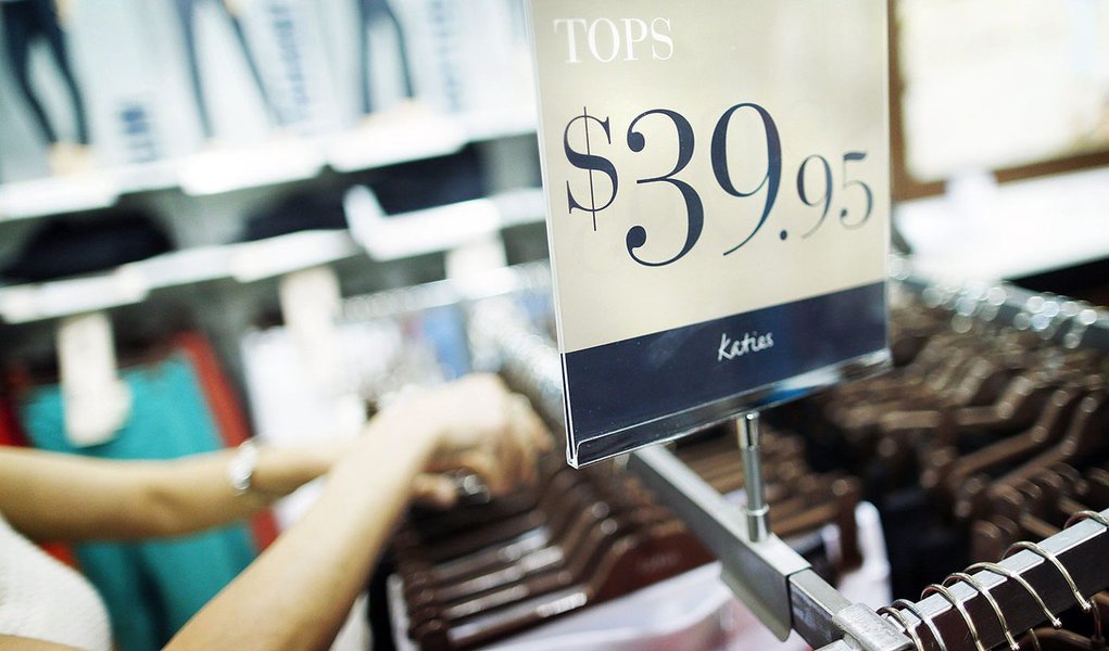 A shop assistant adjusts clothes on hangers at a Specialty Fashion Group owned Katies store in Sydney December 11, 2012. Australia is being invaded by a swathe of foreign retailers, piling pressure on a local industry already battered by weak consumer spe