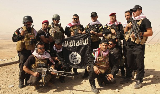 Combatentes curdos Peshmerga posam para foto com uma bandeira do grupo Estado IslÃ¢mico apÃ³s batalha em Zummar, no Iraque. 20/09/2014.   REUTERS/Ari Jalal