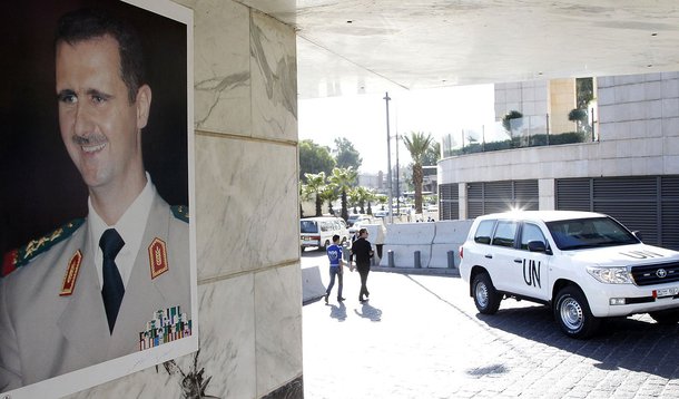 A U.N. vehicle is seen near a photo of Syrian President Bashar al-Assad at the entrance of a hotel where a team of experts from the Organisation for the Prohibition of Chemical Weapons (OPCW) are staying in Damascus October 8, 2013. The global chemical we