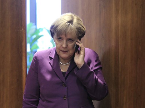 Germany's Chancellor Angela Merkel uses her mobile phone before a meeting at a European Union summit in Brussels in this December 9, 2011 file photo.     REUTERS/Yves Herman