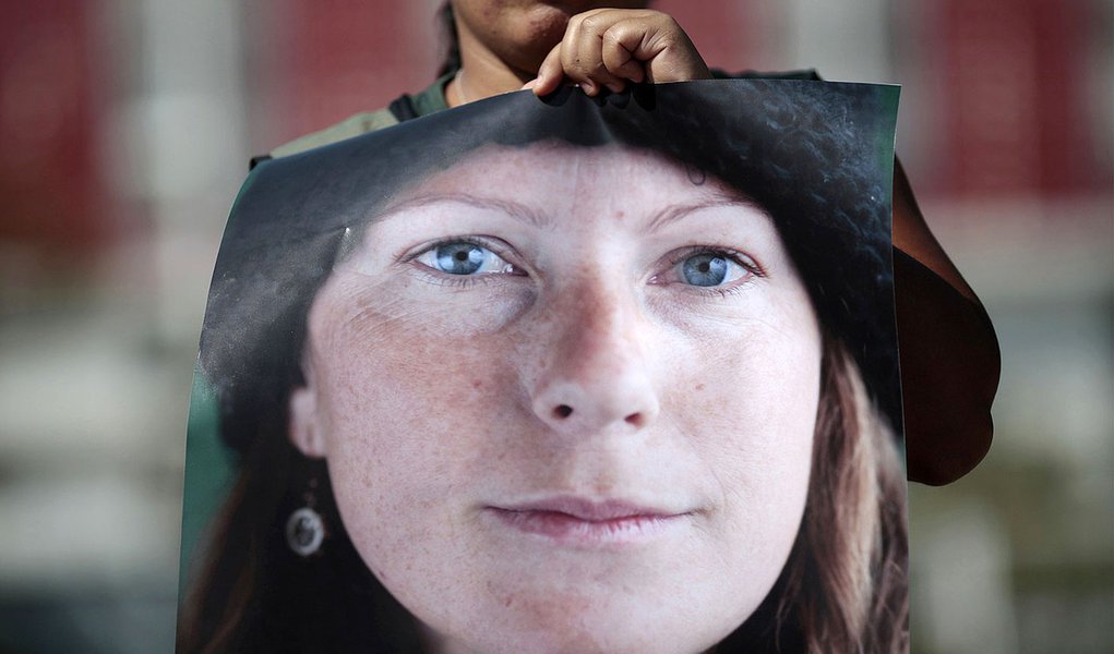 A Greenpeace activist holds a photo of Brazilian Ana Paula Maciel, 31, during a protest in support of activists arrested in Russia, in front of the Russian embassy in Brasilia September 27, 2013. A Russian court ordered 20 Greenpeace activists from around