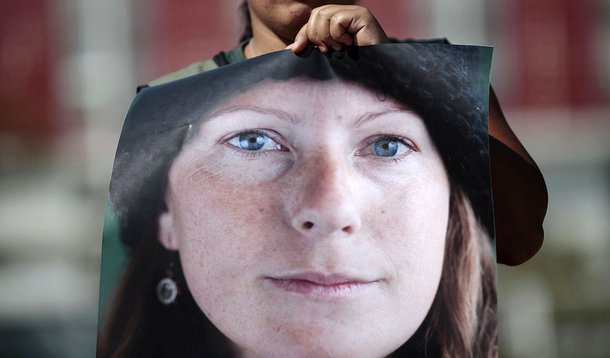 A Greenpeace activist holds a photo of Brazilian Ana Paula Maciel, 31, during a protest in support of activists arrested in Russia, in front of the Russian embassy in Brasilia September 27, 2013. A Russian court ordered 20 Greenpeace activists from around