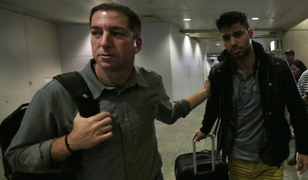 U.S. journalist Glenn Greenwald (L) walks with his partner David Miranda in Rio de Janeiro's International Airport August 19, 2013. British authorities used anti-terrorism powers on Sunday to detain Miranda, the partner of Greenwald, who has close links t