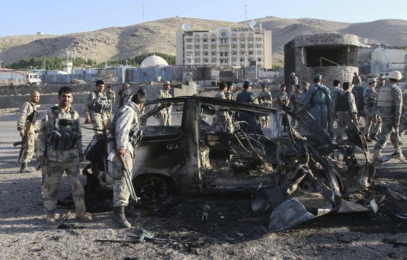 Afghan security forces inspect a damaged car, which was used during a suicide bomb attack, outside the U.S. consulate in Herat province September 13, 2013. At least three people were killed when insurgents attacked the U.S. consulate in Herat on Friday, d