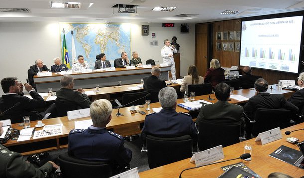 Em pé, Anatalício Risden Júnior, coordenador de Orçamento da Marinha, fala sobre os baixos valores dos orçamentos das Forças Armadas para 2014, em audiência conjunta das Comissões de Relações Exteriores do Senado e da Câmara. Mesa (E/D): secretário geral 