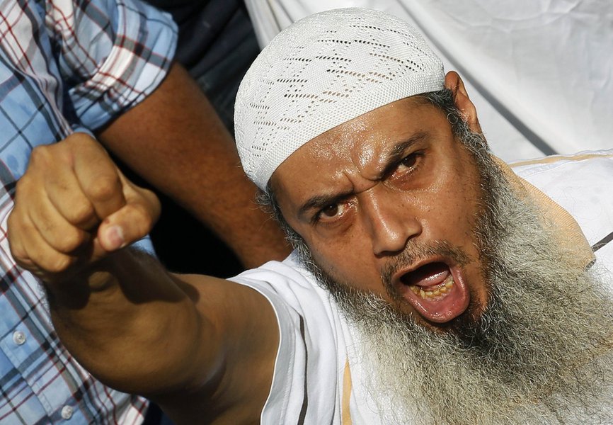 A member of the Muslim Brotherhood and supporter of ousted Egyptian President Mohamed Mursi shouts slogans during clashes in front of Azbkya police station at Ramses Square in Cairo, August 16, 2013. Islamist protests descended into a bloodbath across Egy