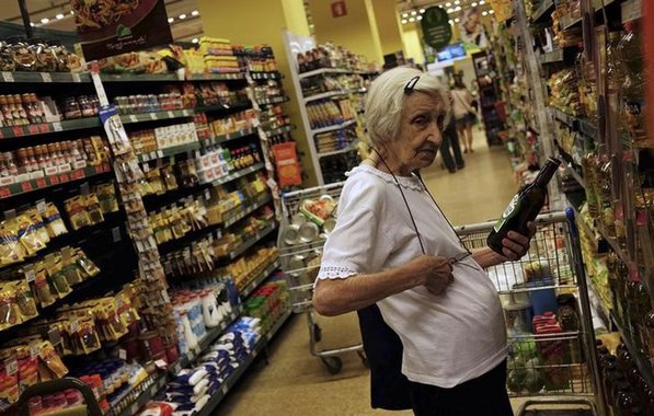 Cliente escolhe uma garrafa de azeite em um supermercado de SÃ£o Paulo. 10/01/2014. REUTERS/Nacho Doce