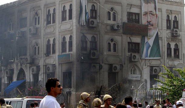 A banner of deposed Egyptian President Mohamed Mursi hangs on a burnt annex building of Rabaa Adawiya mosque after the clearing of a protest camp around the mosque, in Cairo August 15, 2013. Egypt's Muslim Brotherhood called on followers to march in prote