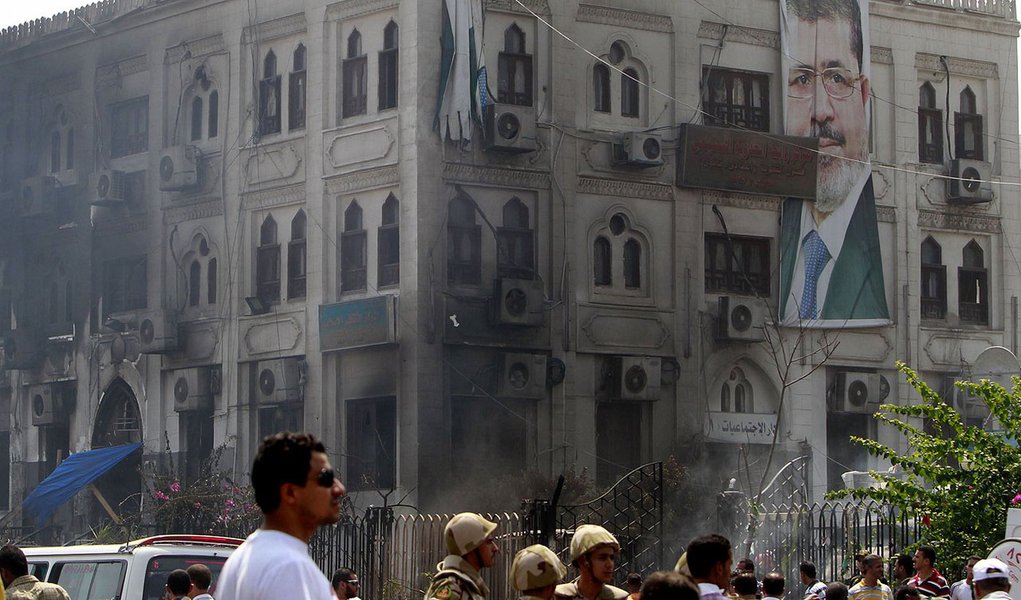 A banner of deposed Egyptian President Mohamed Mursi hangs on a burnt annex building of Rabaa Adawiya mosque after the clearing of a protest camp around the mosque, in Cairo August 15, 2013. Egypt's Muslim Brotherhood called on followers to march in prote