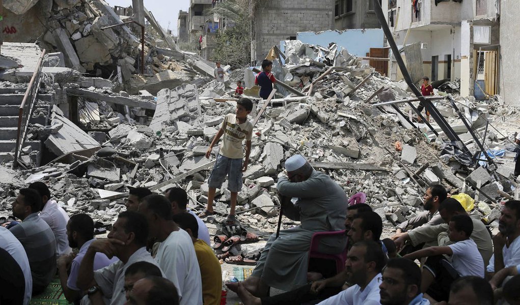 Palestinos rezam perto de restos de mesquita na Faixa de Gaza nesta sexta-feira.  REUTERS/Ibraheem Abu Mustafa