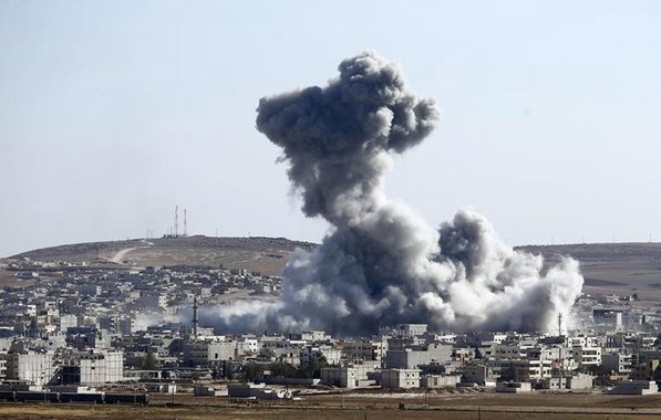 FumaÃ§a em cidade sÃ­ria de Kobani apÃ³s ataque aÃ©reo nesta quarta-feira.  REUTERS/Kai Pfaffenbach