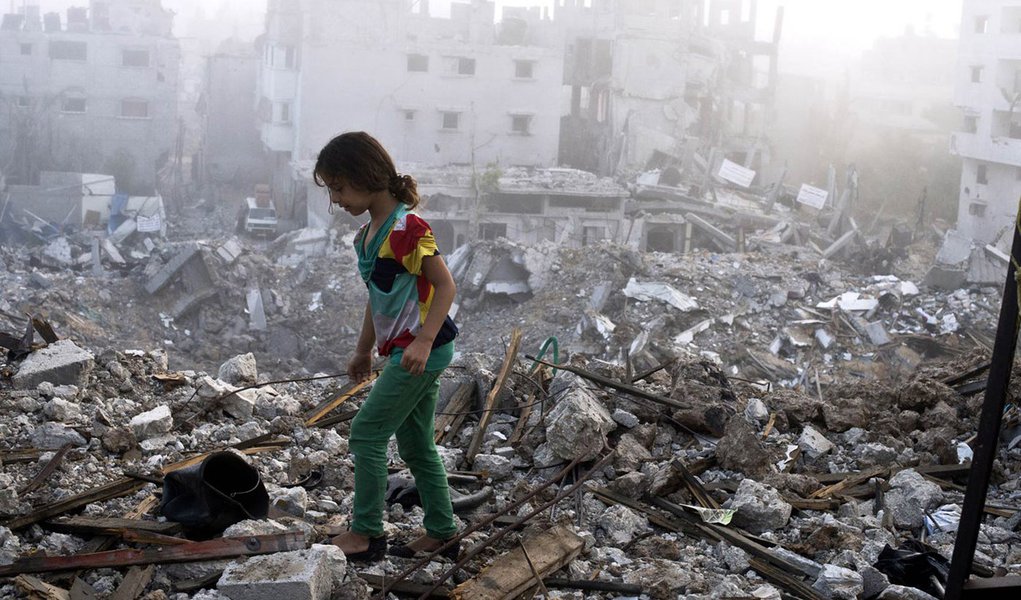 A Palestinian girl walks on the rubble strewn cieling of her family's home after she and other members of her family returned to their partially destroyed house early on August 27, 2014 in Gaza City's Shejaiya neighbourhood which was one of the hardest hi