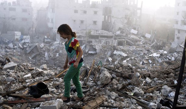 A Palestinian girl walks on the rubble strewn cieling of her family's home after she and other members of her family returned to their partially destroyed house early on August 27, 2014 in Gaza City's Shejaiya neighbourhood which was one of the hardest hi