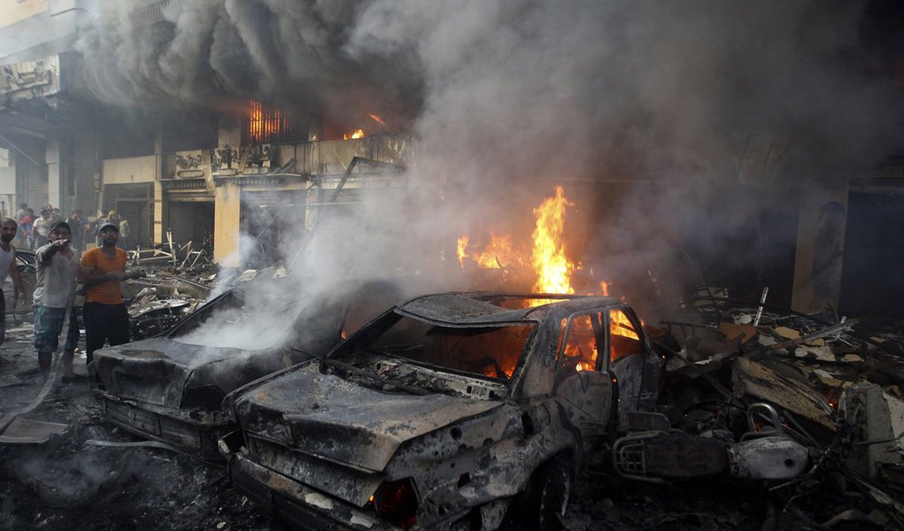 Supporters of Hezbollah try to extinguish a fire from burning cars at the site of a car bomb in Beirut's southern suburbs, August 15, 2013. The powerful car bomb struck the southern Beirut stronghold of Lebanon's militant Hezbollah group on Thursday, kill